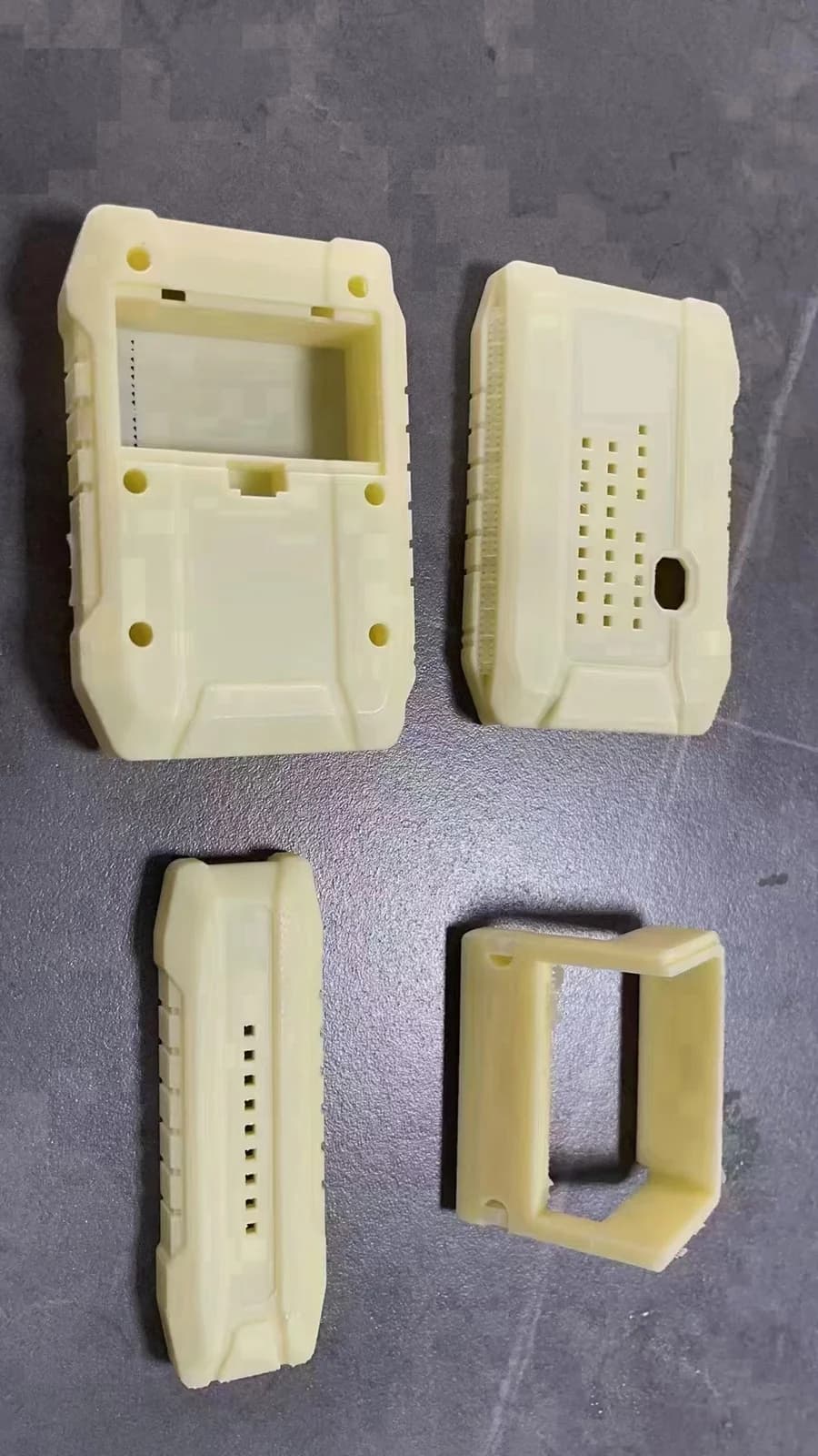 分开的壳体样件露出开孔、安装柱和分件关系，用于讨论结构与装配